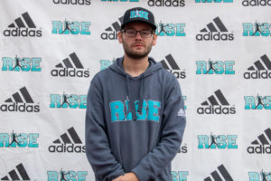 Man wearing a blue hoodie and cap at an Adidas event.